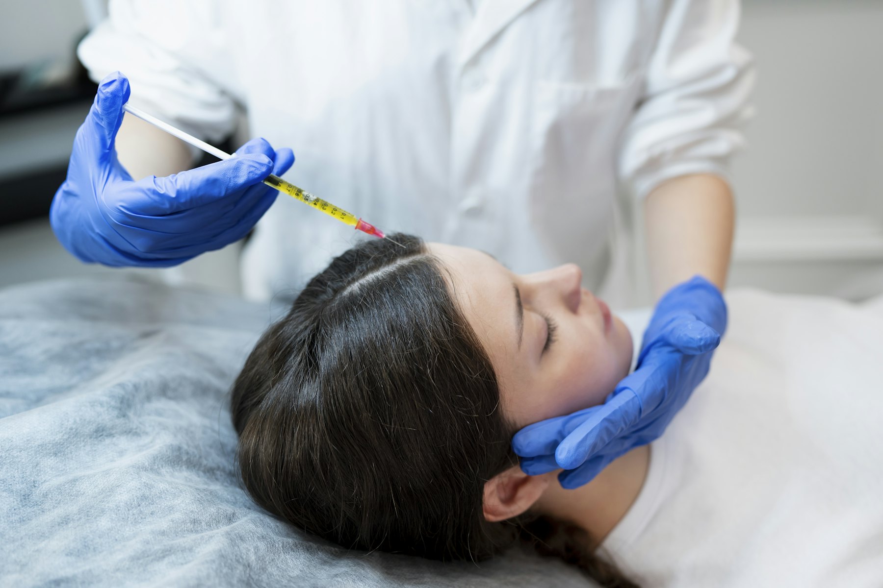 A physician injecting a client’s forehead