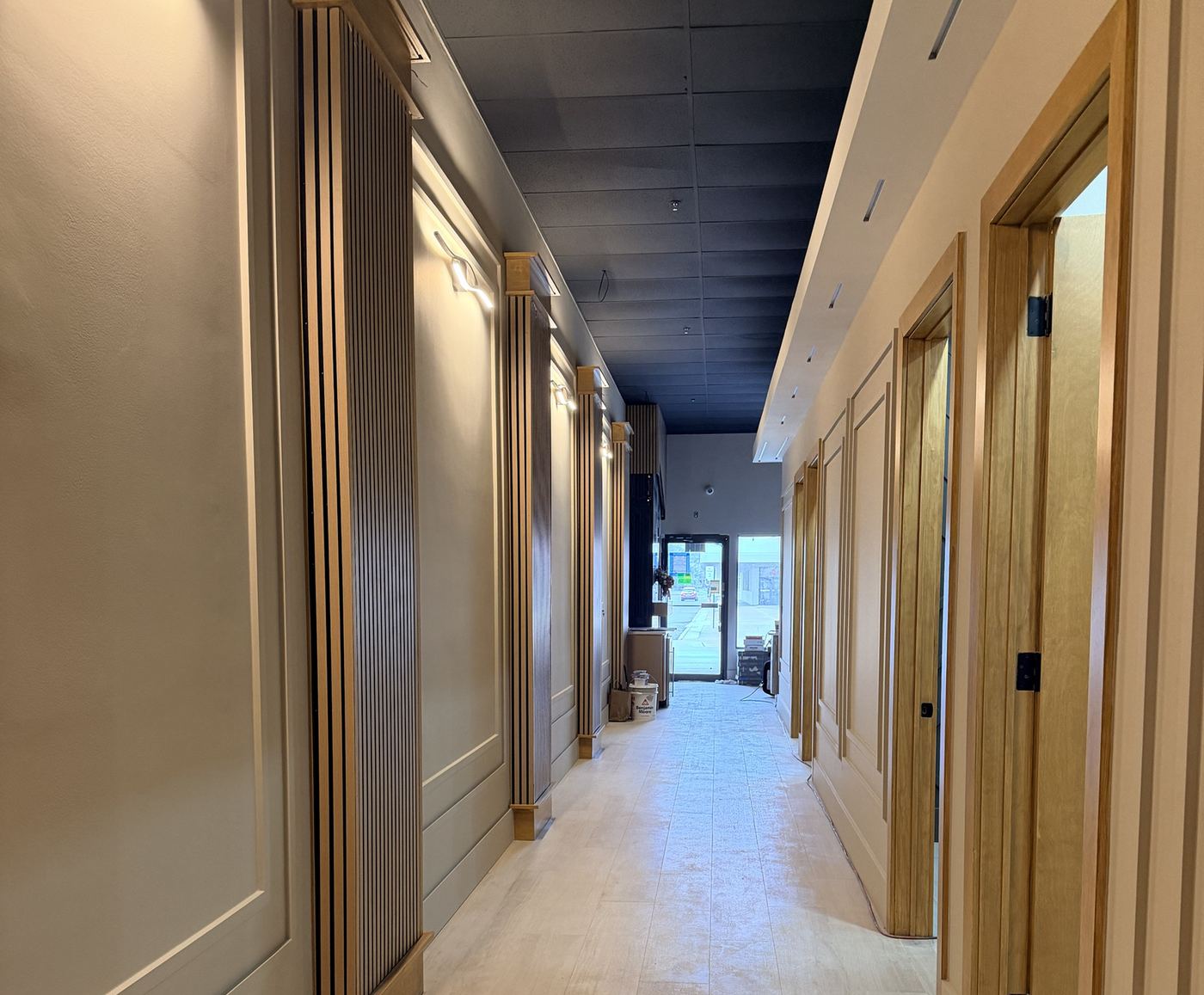 The studio hallway: white oak slat columns and warm walls